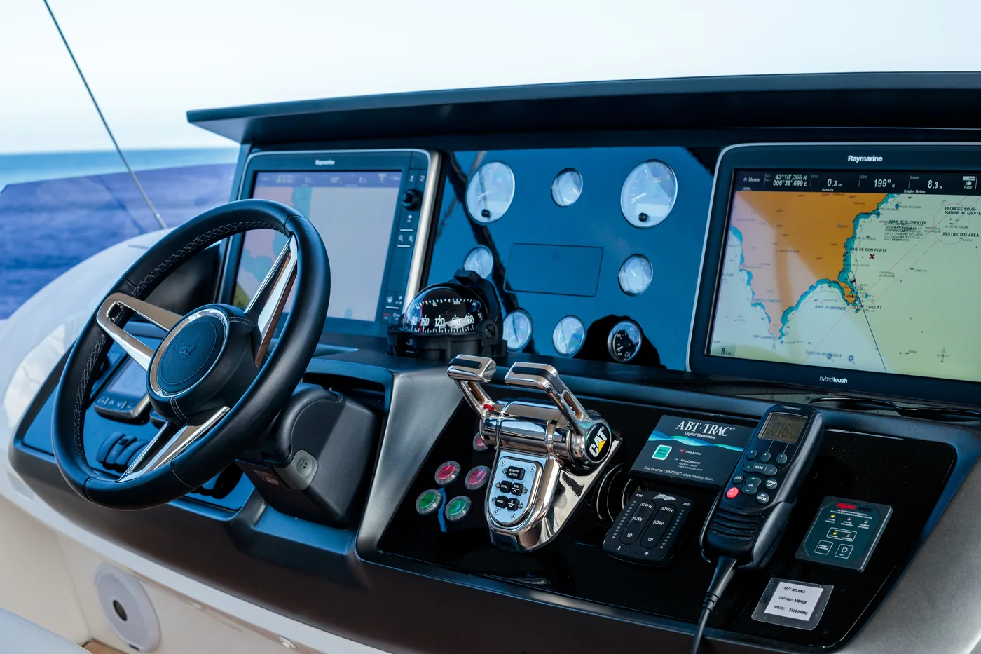 Yacht helm with navigation displays, wheel, and engine controls